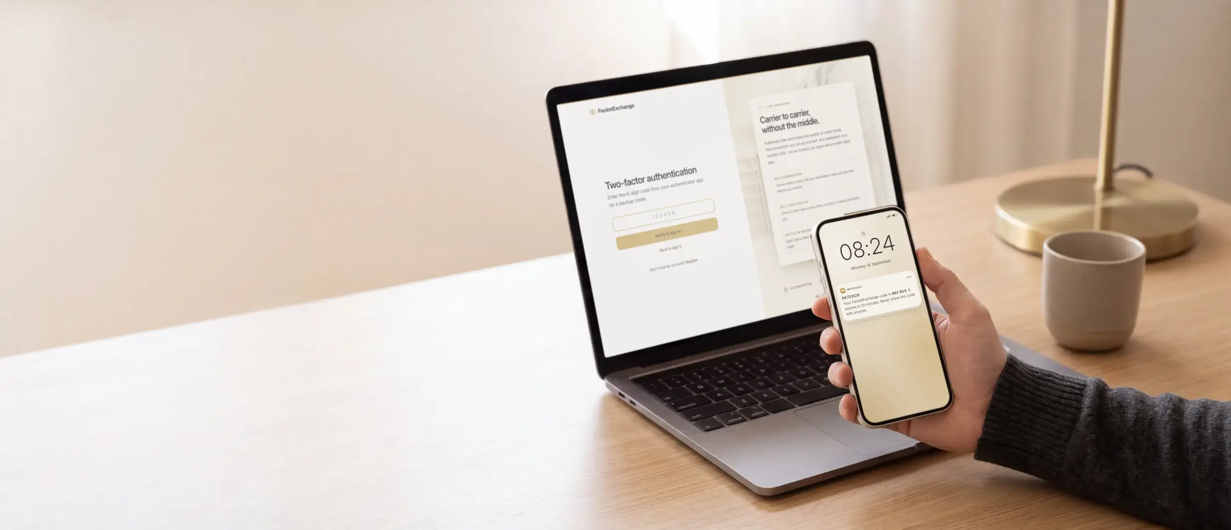 A laptop at a two-factor sign-in step while a phone in hand shows a one-time code
